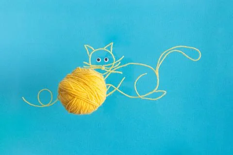 Drawing of yellow cat from wool threads with ball integrated knitting creative Stock Photos