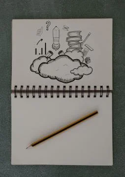 Drawings of clouds and books in notepad Stock Photos
