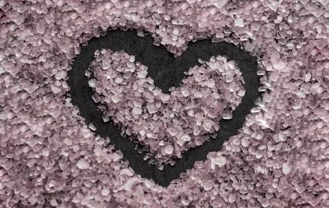 Drawn heart on a background of pink salt. Heart drawn in pink Himalayan salt. Stock Photos