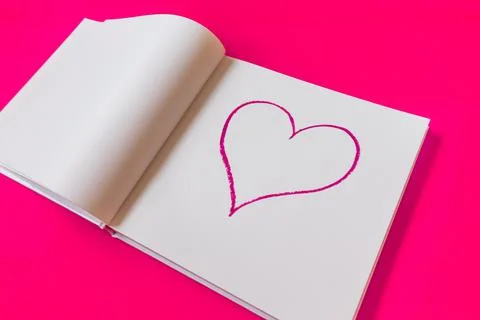 Drawn heart in a notebook on a pink background. Happy Valentine's Day. Stock Photos