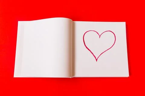 Drawn heart in a notebook on a red background. Happy Valentine's Day. Stock Photos