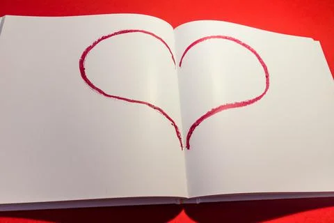 Drawn heart in a notebook on a red background. Happy Valentine's Day. Stock Photos