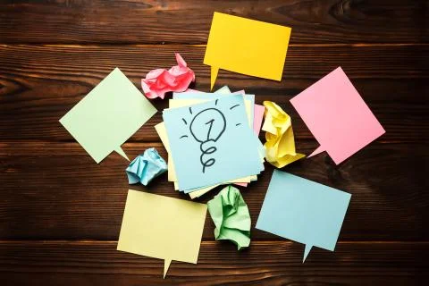 Drawn light bulb sticky note surrounded by crumpled paper Stock Photos