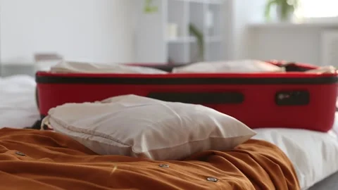 Drawstring bag with clothes and packing cubes in suitcase on bed indoors Stockbeeldmateriaal 305928914