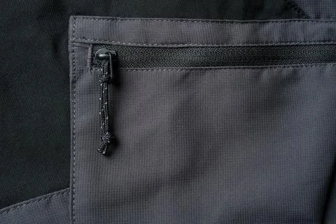 Drawstring zipper of dark gray outdoor trouser pocket Stock Photos