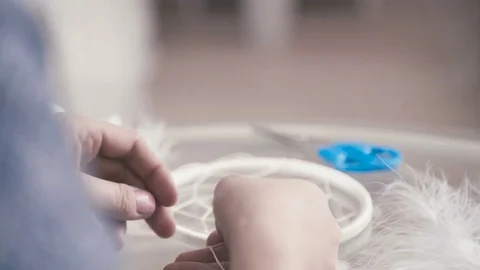 Dreamcatcher: the process of creating. Openwork weaving of white thread Stock Footage 72966163