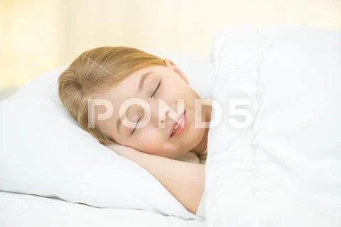 The dreaming girl lay on the bed Stock Photos