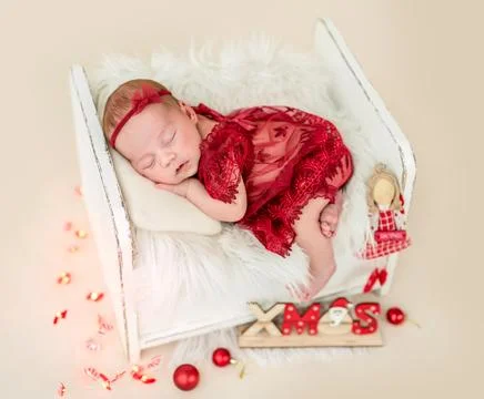 Dreaming newborn in tiny bed Stock Photos