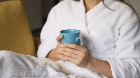 Dreaming Woman Enjoys Coffee in Armchair Stock Footage