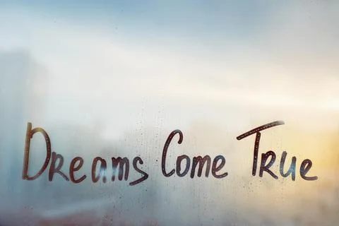 Dreams come true message written finger on foggy glass wet sunset window Stock Photos