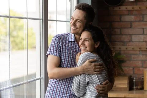 Dreamy loving young couple visualizing future together at home. Stock Photos