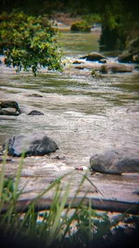 A dreamy, soft-focus view of a river flowing over rocks. Stock Photos