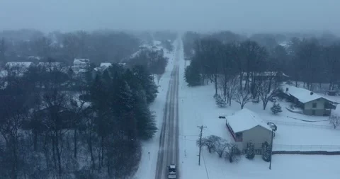 Dreary winter drone flying down a country road with truck slowly driving 库存影片 250030177