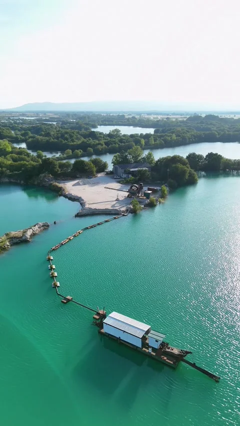 Dredge boat mining sand in an emerald green quarry lake in Galicia Stock Footage 339321789