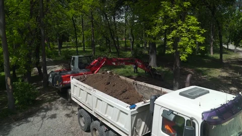 Dredge excavating ground and loading tipper truck, high angle view, crane shot. Stock Footage 76693797