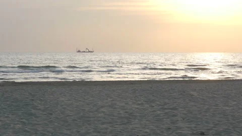 Dredge ship sails on the horizon, in a late afternoon warmed by the golden light Stock Footage 172382219