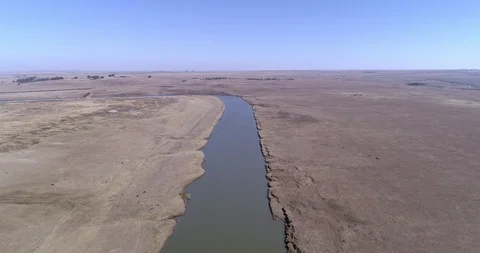 Dredged river bend in the distance seen from the sky with highway on the dry  Stock Footage 111962656