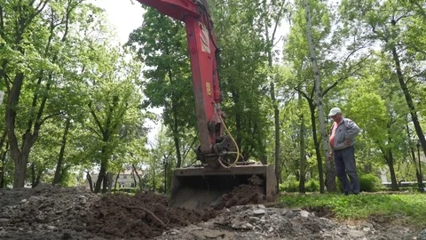 Dredger digging ground and loading dump truck, tilt up, crane shot. Stock Footage 76656575