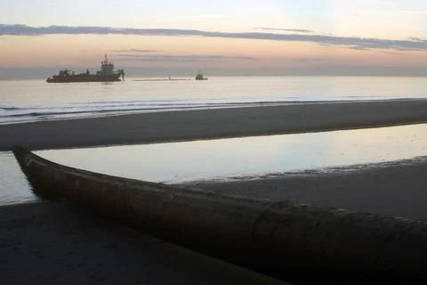 A dredger supplying sand to a beach Stock Photos
