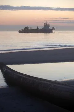 A dredger supplying sand to a beach Stock Photos