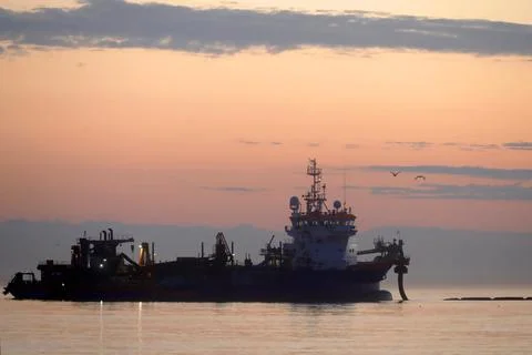 A dredger supplying sand to a beach Stock Photos