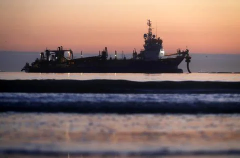A dredger supplying sand to a beach Stock Photos