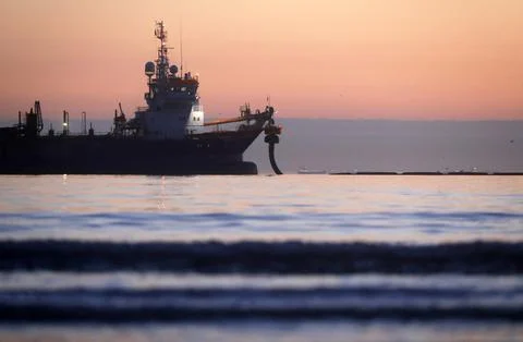 A dredger supplying sand to a beach Stock Photos