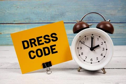 Dress Code text written on paper card with alarm clock on wooden background Stock Photos