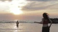 dressed woman in love runs to her man into the sea - hugs and kisses - sunset HD Footage