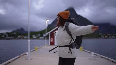 Dressed in a wool sweater and hat, a young traveler girl carrying a backpack Stock Footage 252343890
