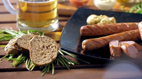Dressing bratwurst with mustard during a breakfast. Warm and tasty mood. Stock Footage 69809603