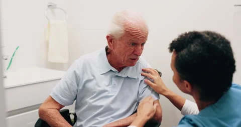Dressing, caregiver or old man in bathroom with wheelchair, grooming help or Stock Footage 338426152