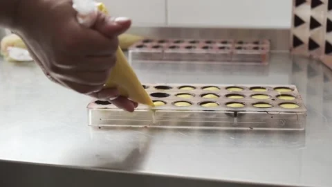Dressing chocolates with yellow mango and passion fruit filler Stock Footage 132800255