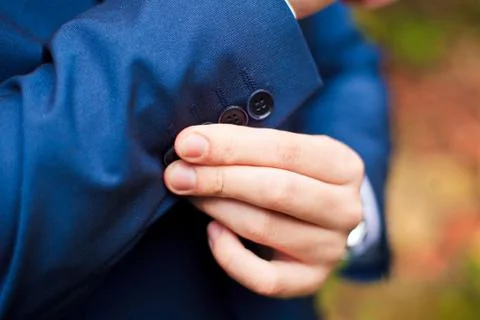 Dressing. Closeup of a man in jacket correcting sleeves Stockfoto's