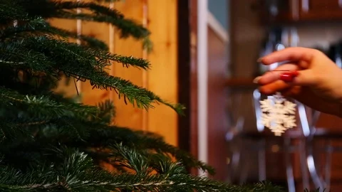 Dressing a decorative snowflake on a christmas tree by a womans hand Stock Footage 122500917