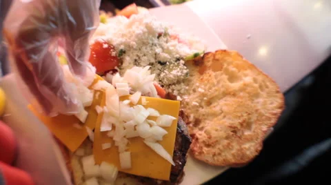 Dressing a hamburger with onions Stockbeeldmateriaal 41919769