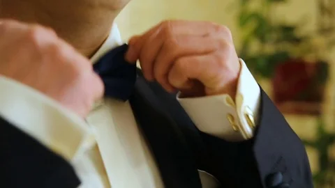 Dressing man straightens bow-tie shallow depth of field Stock Footage 83006583