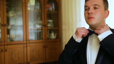 Dressing man straightens bow-tie shallow depth of field Stock Footage 83007004