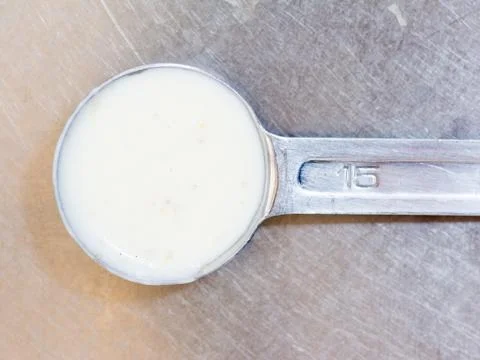 Dressing in the measuring spoon Stock Photos
