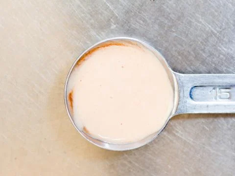 Dressing in the measuring spoon Stock Photos