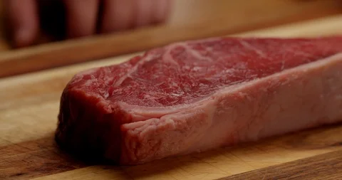 Dressing New York steak with olive oil and spices Видео 126257986
