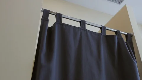 In the dressing room of the boutique through the closed curtain, the buyer Stock Footage 112342735