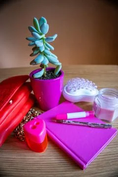 On the dressing table bag, flower, notebook, pen, candle all in pink tone Stock Photos