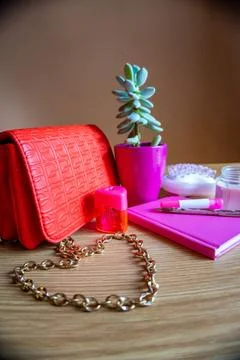 On the dressing table bag, flower, notebook, pen, candle all in pink tone Stock Photos