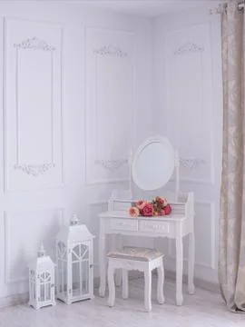Dressing table with a mirror and flowers in the room. Photos