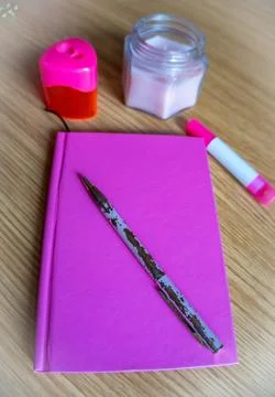 On the dressing table notebook, pen, candle all in pink tone Stock Photos