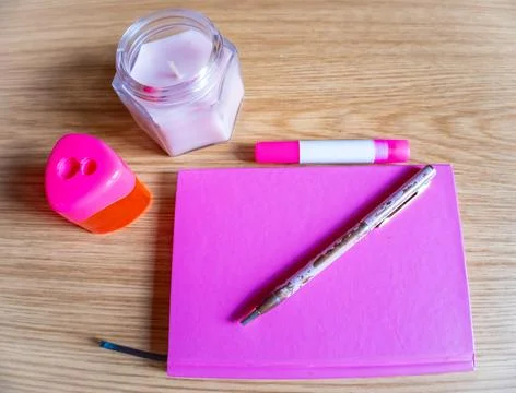 On the dressing table notebook, pen, candle all in pink tone Stock Photos