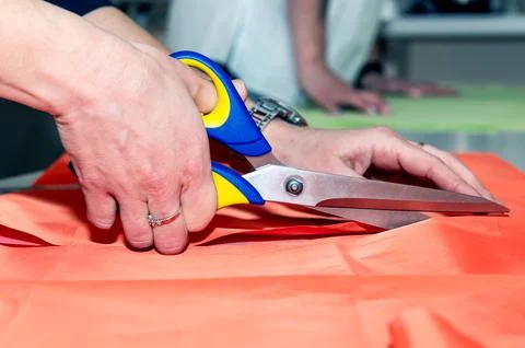 Dressmaker cuts fabric with scissors. Process of making a piece of clothing. Foto stock