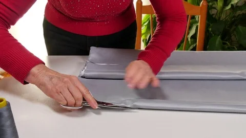 Dressmaker Cutting and Folding Clothes with Scissors Stock Footage 80558092