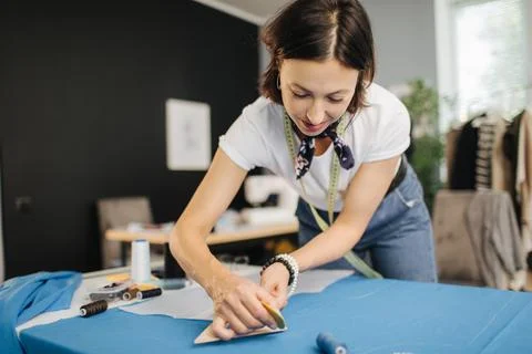 Dressmaker a making patterns on blue fabric Stock Photos